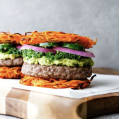 A burger with spiralized carrot buns from CookAtHomeMom.