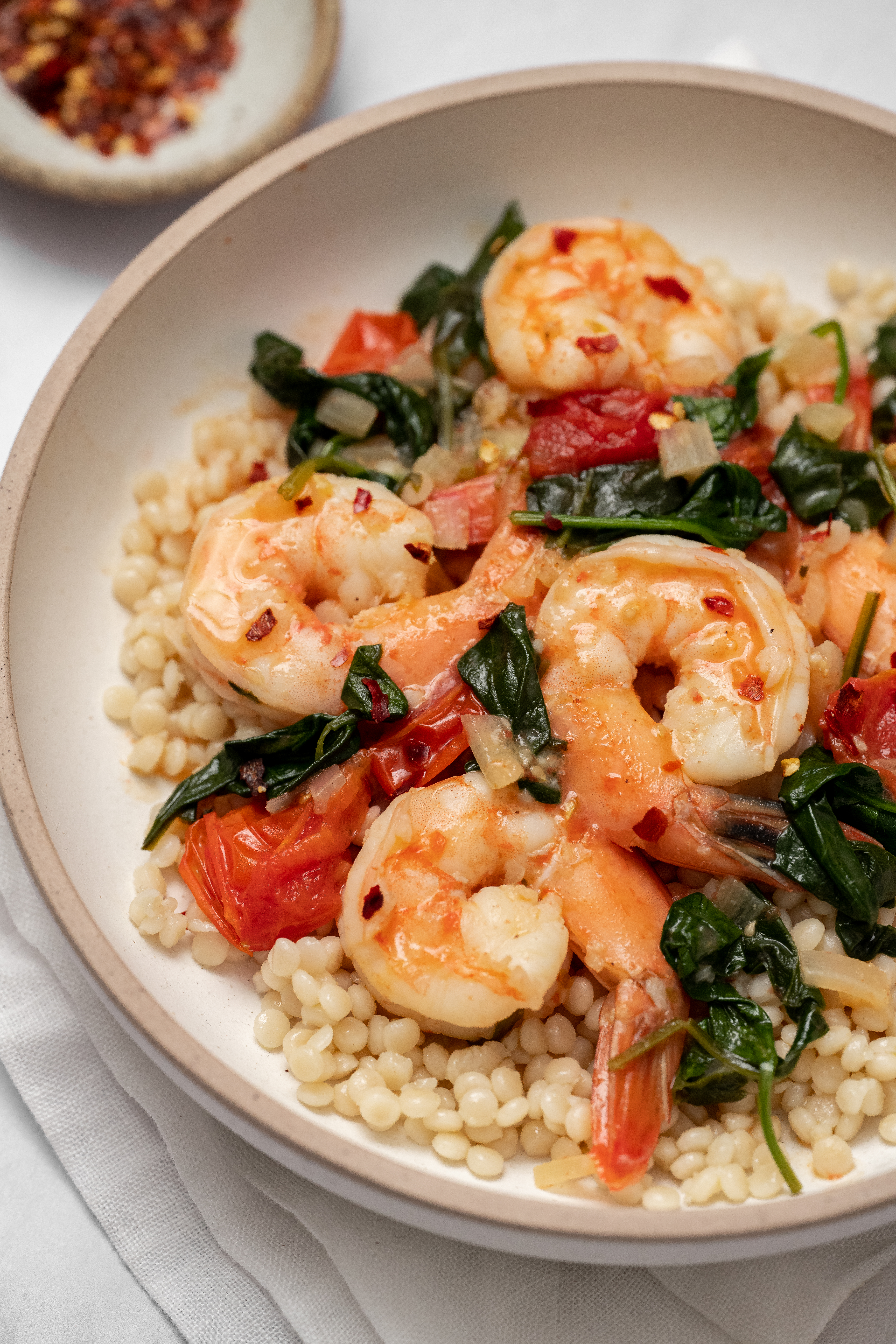 Prawns, spinach and tomatoes in a lemon garlic cream sauce with couscous